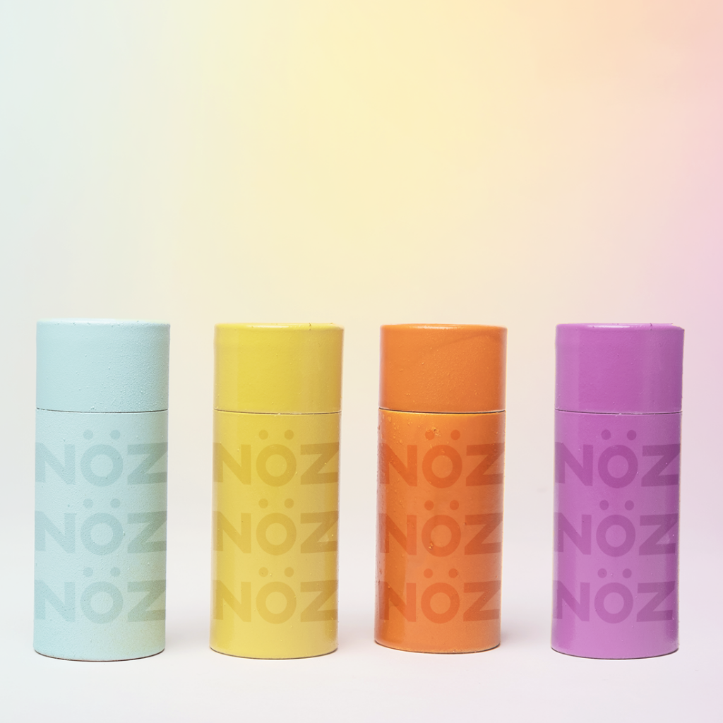 Four sticks of nozscreen in line, blue, yellow, orange, purple